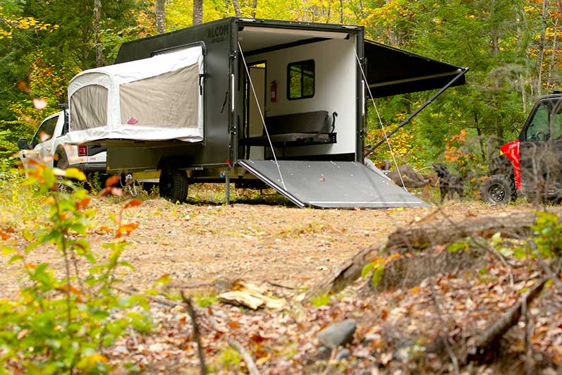 An ALCOM Offroad, Caldera model, large overland camper with an UTV access door.