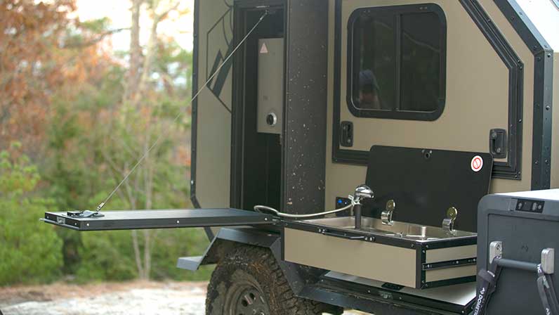 An ALCOM Offroad Oxbow overland camper with cookstove/burner sink combo.