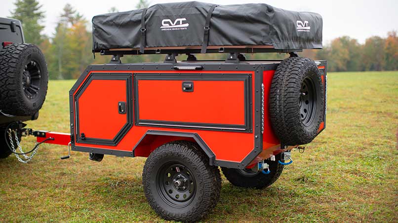 A Spur overland camper being towed by a Jeep.